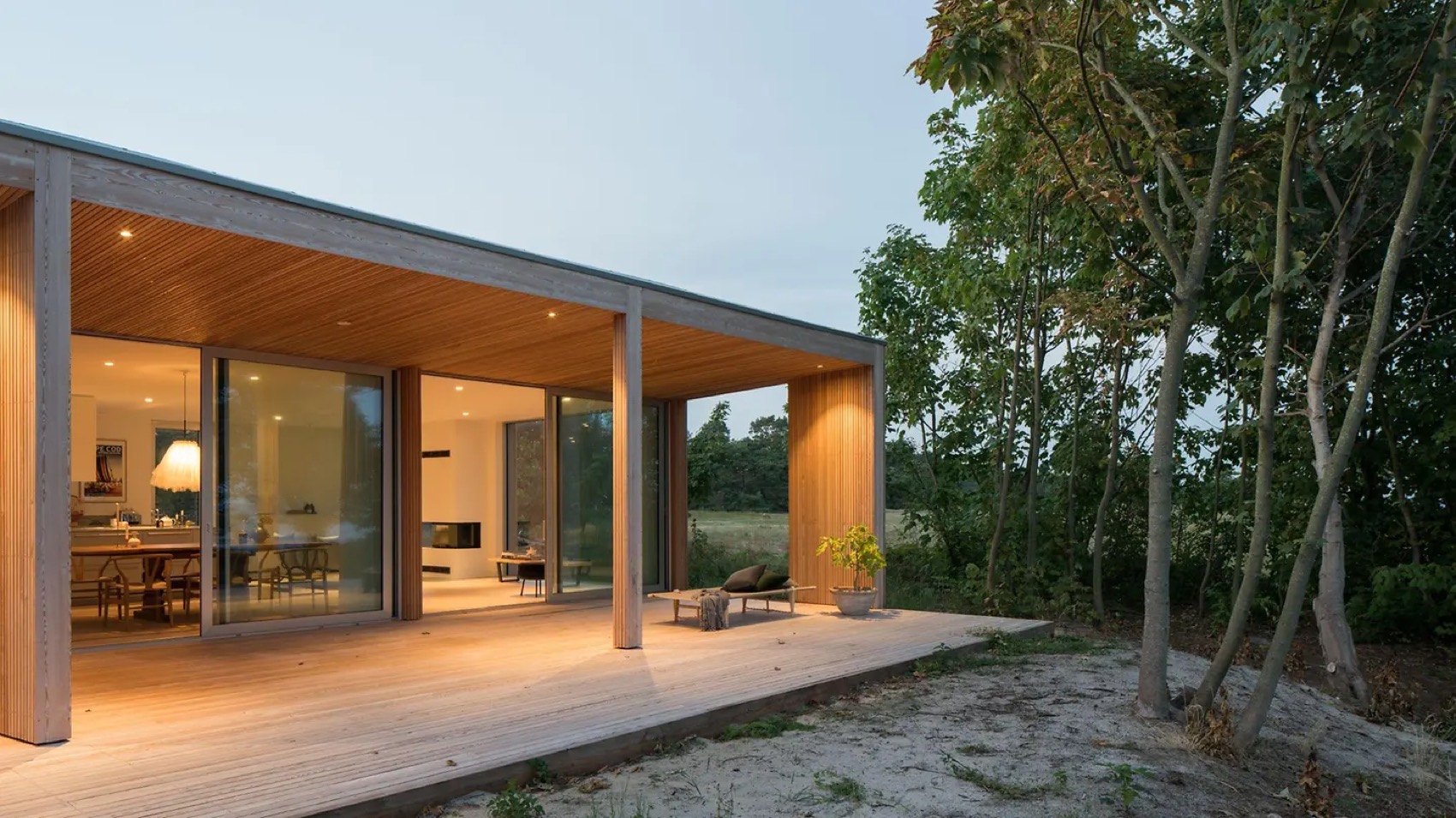 Modernes Holzhaus mit großen Glasflächen in der Abenddämmerung
